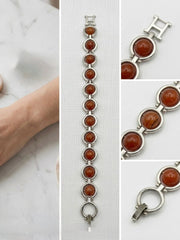 Vintage silver-tone bracelet with round orange cabochon stones and geometric link design.