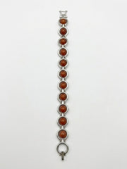 Vintage silver-tone bracelet with round orange cabochon stones and geometric link design.